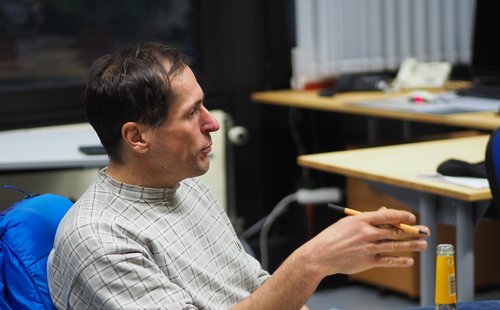 ein Mann Mitte fünfzig spricht und gestikuliert dabei mit seiner Hand 